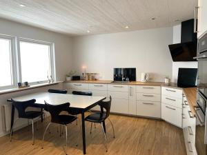 a kitchen with white cabinets and a table and chairs at The Northern Escape in Klaksvík
