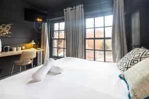 a bedroom with a white bed and a window at GuestReady - Rose and Monkey Hotel in Manchester