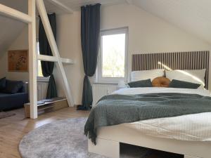 a bedroom with a large bed and a window at Gemütliches Mansarden-Apartment mit 2 Schlafzimmern & separater Küche in Herne