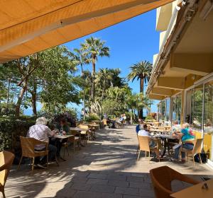 Eine Gruppe von Menschen sitzt an Tischen in einem Restaurant in der Unterkunft Hotel Tigaiga in Puerto de la Cruz