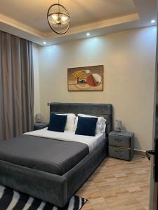 Un dormitorio con una cama grande con almohadas azules. en Munyonyo apartments, en Kampala
