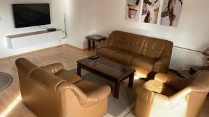 a living room with leather furniture and a flat screen tv at BT Lux apartment 2 in Skopje