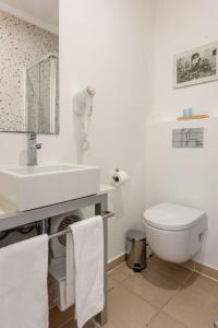 リスボンにあるCasa com Graça - Fully equiped Studio in the Historical Centerの洗面台とトイレを備えた白いバスルーム +9枚の写真