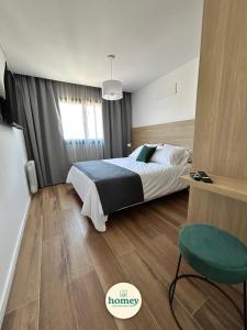 a bedroom with a bed and a green chair at HOMEY Departamentos in Mar del Plata +44 photos