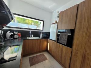 a kitchen with wooden cabinets and a sink and a window at Casa Spruit in Rojales
