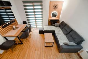 a living room with a couch and a table and a piano at Gorski Elegance 1 in Zlatibor