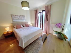 una camera da letto con un letto bianco e cuscini rosa di Rooms Irena Gregov a Mošćenička Draga