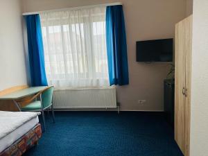 a hotel room with a bed and a window with blue curtains at Hotel KM in Darmstadt