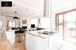 a kitchen with white counters and a large window at Villa Corasao Luxury in La Zubia