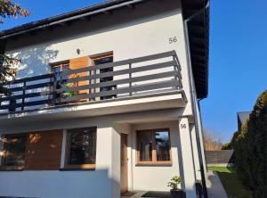 a white house with a balcony on top of it at Ohouse aparts in Ciechanów