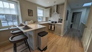 a kitchen with a counter and two stools at The Nest - One Bed Apt with Sea Views in St. Brelade