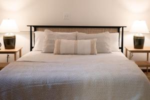 ein Schlafzimmer mit einem großen Bett mit zwei Lampen in der Unterkunft Wooded Cottage in Elizabethtown with hot tub and sauna in Elizabethtown