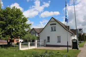 a white building with a flag on top of it at Pension Goerke in Kritzkow