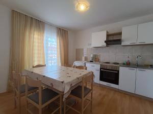 a kitchen with a table and a table and chairs at Apartmani JT Zadar in Zadar +23 photos