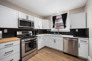 een keuken met witte kasten en roestvrijstalen apparaten bij Peaceful 2BD - Perfect for Long-term stays in Peoria