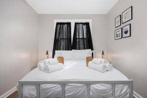 een witte slaapkamer met een groot bed en witte handdoeken bij Peaceful 2BD - Perfect for Long-term stays in Peoria