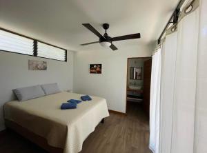 a bedroom with a bed and a ceiling fan at Casa Eden in Tamarindo