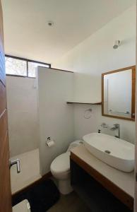 a bathroom with a toilet and a sink and a mirror at Casa Eden in Tamarindo +31 photos