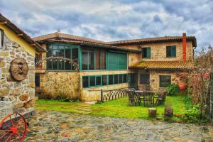 a large stone house with a green door at Hotel rústico Aldea Figueiredo in Ourense