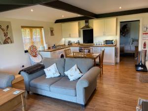 a living room with a couch and a kitchen at The Horseshoe Cottage in Alkham +9 photos