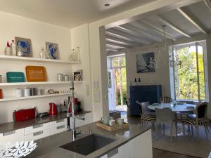 Una cocina y un comedor con una mesa y un fregadero. en Une pause sous les palmiers - île aux moines, en Ile-aux-Moines 31 fotos más