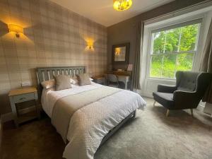 a bedroom with a bed and a chair and a window at Crown & Crossed Swords in Shotley Bridge