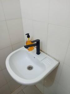 a white bathroom sink with a soap dispenser on it at JOLI APPARTEMENT A DAKAR,ESPACES MAMELLE in Dakar +5 photos