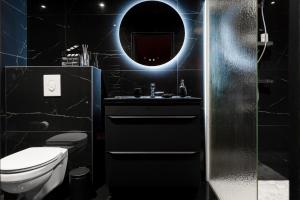 a black bathroom with a toilet and a mirror at Ciné'Room, votre suite cinéma et spa à Nancy in Nancy +9 photos