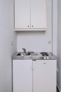 a kitchen with white cabinets and a sink at Casa del Sol in Kouniádhoi