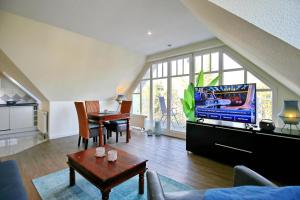 a living room with a tv and a dining room at Villa Seepferdchen Wohnung 10 in Kühlungsborn
