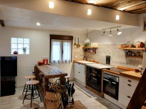 a kitchen with white cabinets and a wooden counter top at casa típica asturiana in Avilés