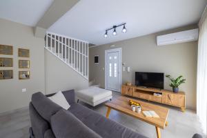 a living room with a couch and a tv at Taras Residence in Karavádhos