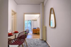 un soggiorno con tavolo, sedie e uno specchio di Prime and Cosy 1bedroom Hop to Acropolis ad Atene