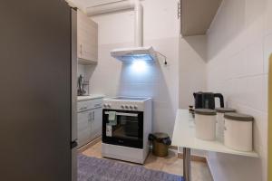 una cucina con piano cottura e tavolo di Prime and Cosy 1bedroom Hop to Acropolis ad Atene Altre 8 foto
