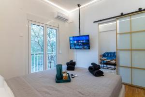una camera da letto con un letto e una tv a parete di Prime and Cosy 1bedroom Hop to Acropolis ad Atene