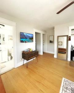a living room with a table and a tv on the wall at Chateau Blanc Yale Located Downtown in New Haven