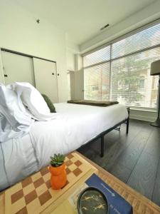 a bedroom with a large white bed and a table at Yale Modern Downtown Chateau in New Haven