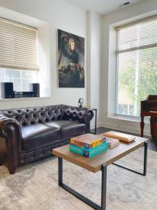 a living room with a leather couch and a coffee table at Yale Modern Downtown Chateau in New Haven