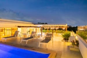 a house with a swimming pool and a patio at Hotel Stay Here Suites in Santo Domingo