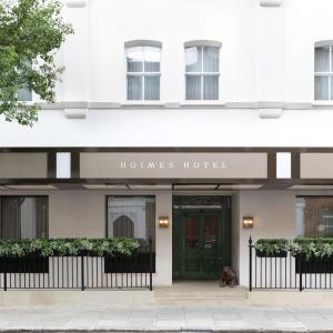 a dog sits in front of a hotel at Holmes Hotel London in London