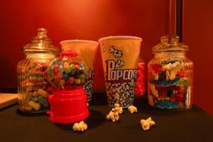 a table with three glass jars filled with candy at Ciné'Room, votre suite cinéma et spa à Nancy in Nancy