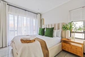 Un dormitorio con una cama con almohadas verdes y una ventana. en Tranquil Urban Oasis with FREE Gym and Pool, en Sandton 47 fotos más
