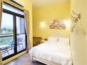 una camera con un letto bianco e una grande finestra di Lancasa Taitung a Città di Taitung