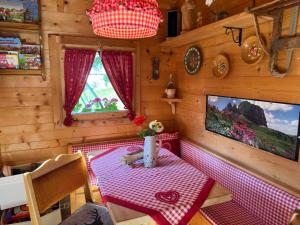 a small dining room with a table and a tv at Untertalhof in Castelrotto