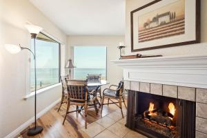 a living room with a fireplace and a table and chairs at SurfSong Dream - Beachfront in Solana Beach