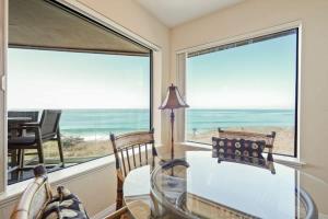 a dining room with a view of the ocean at SurfSong Dream - Beachfront in Solana Beach