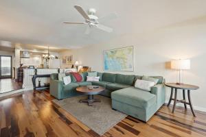 a living room with a green couch and a table at SurfSong Dream - Beachfront in Solana Beach