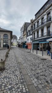 a cobblestone street in a city with buildings at **La Bretonnerie, bel appartement de standing in Concarneau
