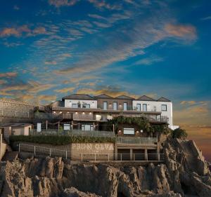 a building on top of a rocky cliff at Pedn-Olva in St Ives