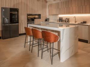 - une cuisine avec un comptoir et des tabourets dans l'établissement Villa Corsa - luxury villa in Istria, à Barban